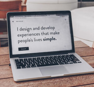 An image that promotes professional web design by saying" I design and develop experiences that make people's lives simple." on a laptop screen